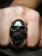 Reliquia del Devorador Antique: Anillo de calavera de acero con acabado envejecido oscuro estilo osario usado en el puño en Chile.