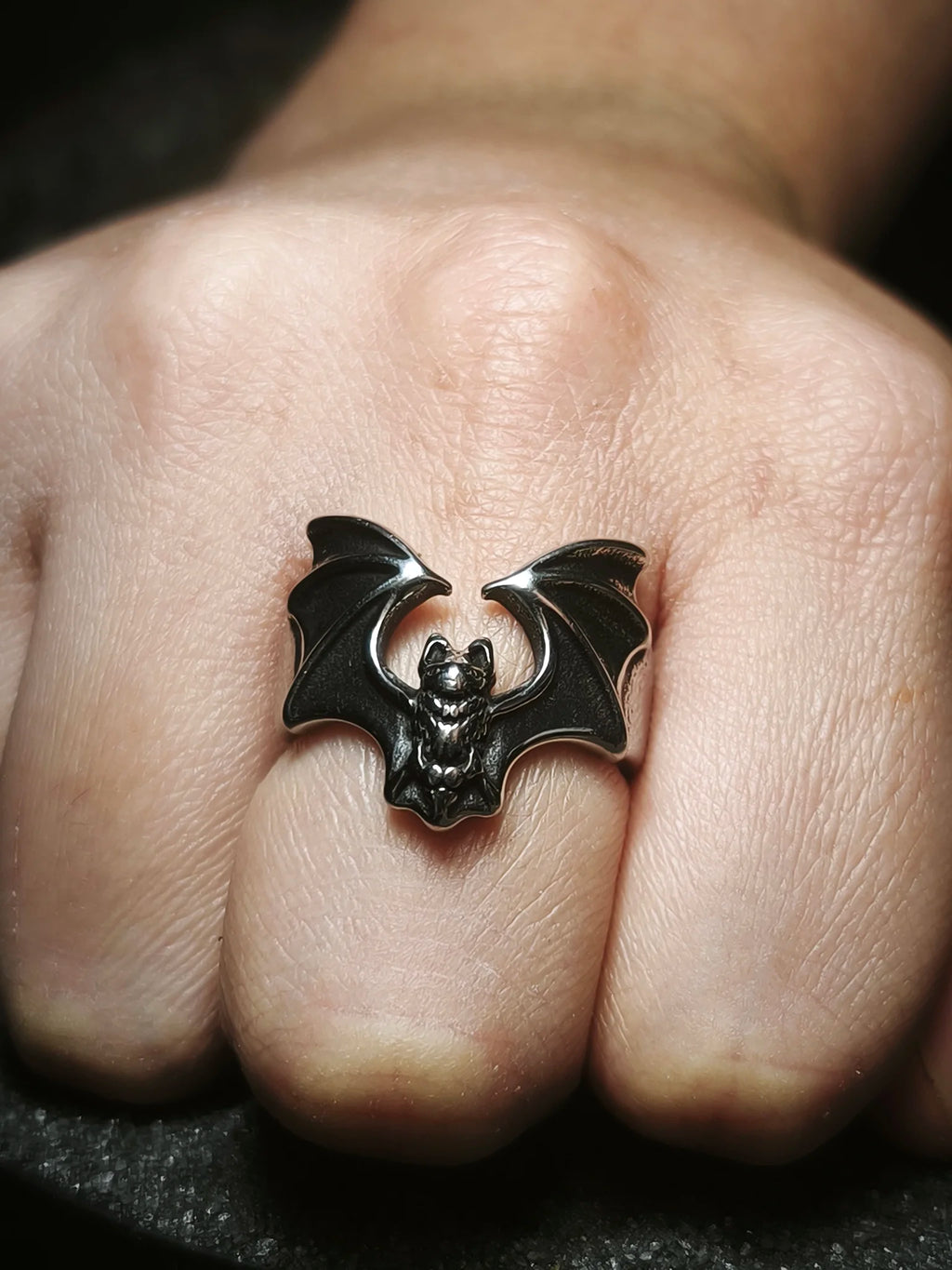 Soberano de las Sombras: Vista frontal de anillo de murciélago vampírico macizo en acero inoxidable usado en la mano en Chile.