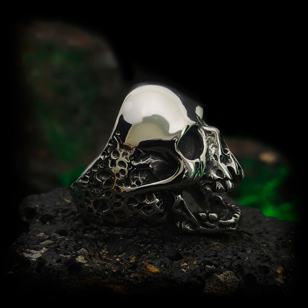 Vista lateral del anillo calavera El Clamor de Baudelaire en acero macizo con relieve óseo y calota pulida | Abyssal Relics.