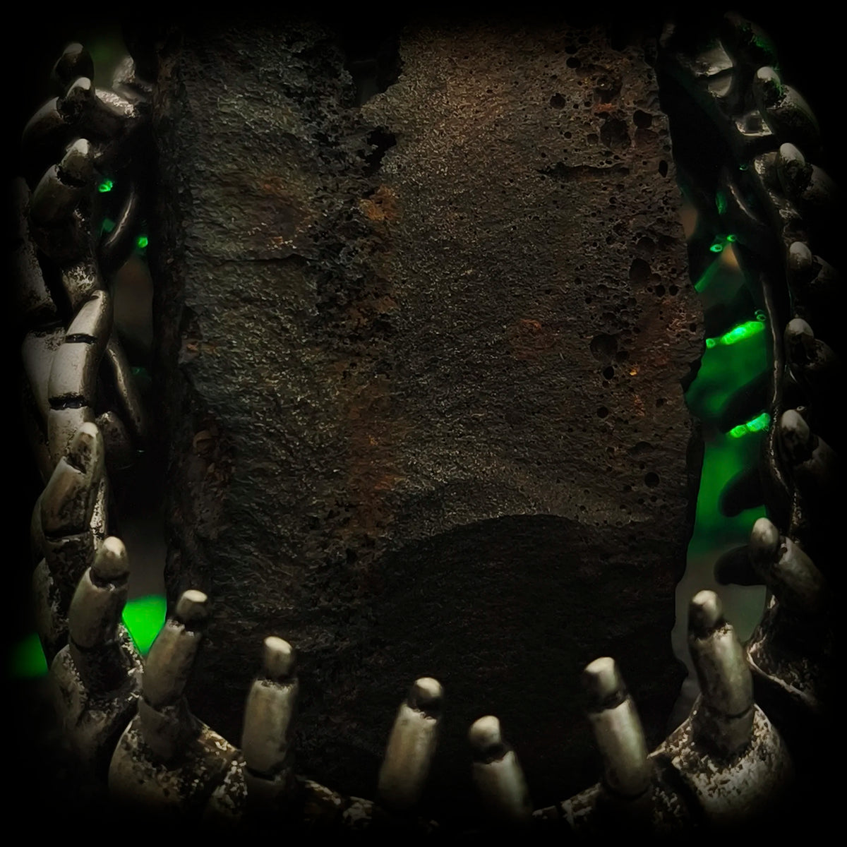 Vista lateral del brazalete exoesqueleto El Parásito de Yuggoth ceñido en roca | Joyería Abyssal Relics.