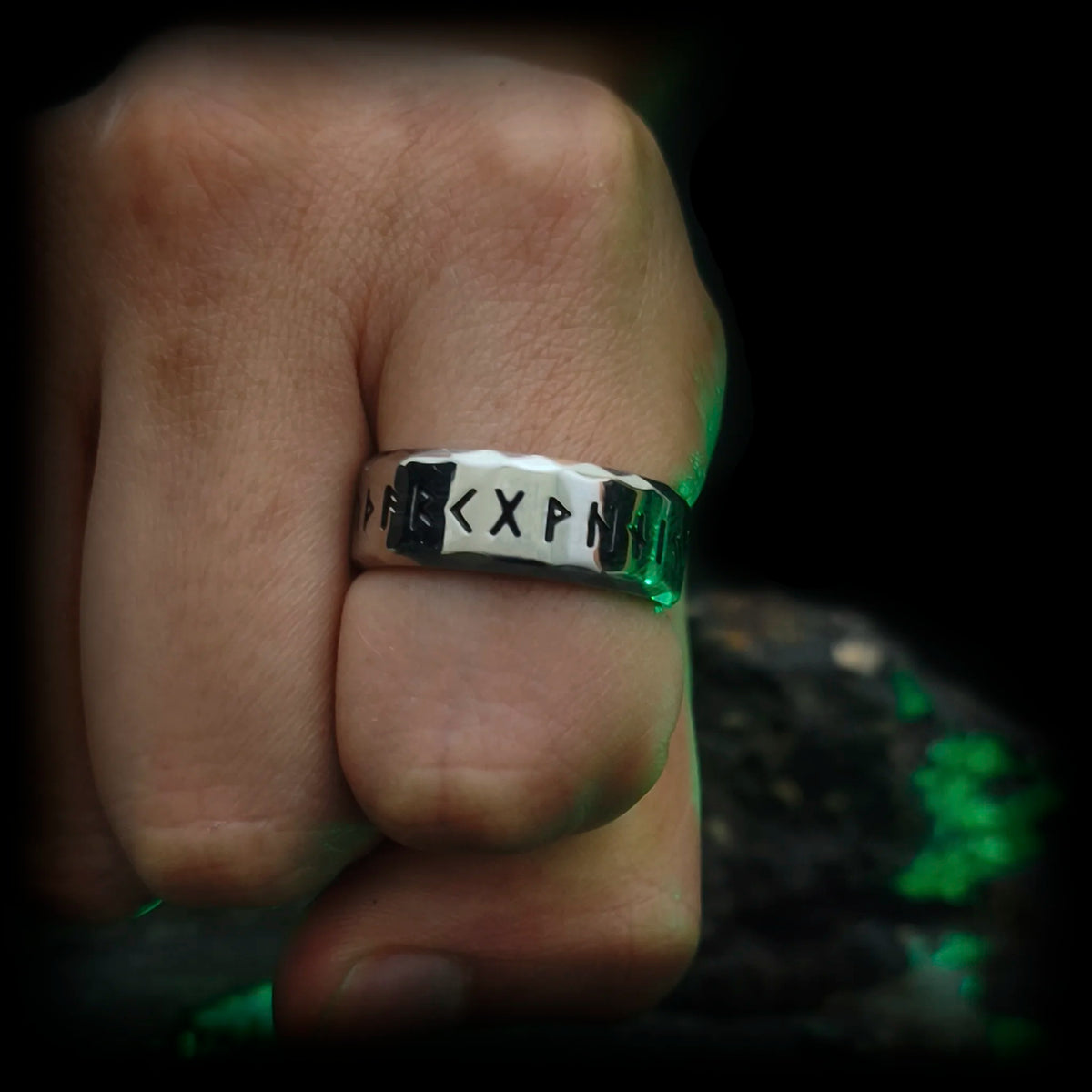 Anillo vikingo con runas nórdicas El Rúnatal de Odín puesto en mano de hombre | Joyería de acero Abyssal Relics.