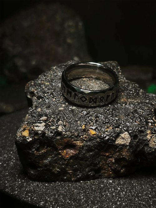 Legado de las Runas: Foto de portada de anillo vikingo facetado con grabado del alfabeto futhark en acero de alta densidad sobre roca volcánica en Chile.